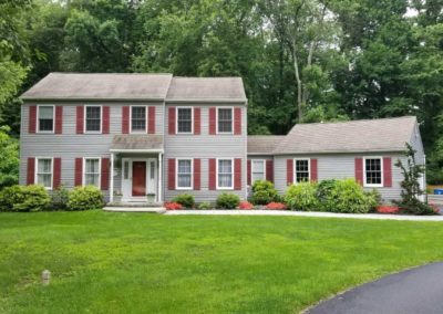 A large house with red shutters and white trim.