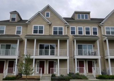 A row of houses with red doors and windows.