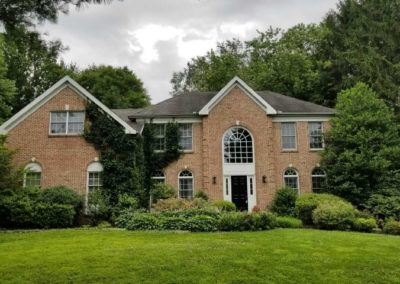 A large brick house with green grass in front of it.