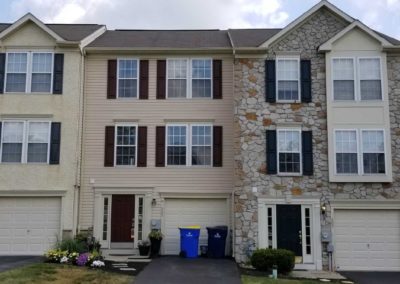 A row of houses with garage doors and windows.