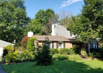 A house with trees and bushes in the background