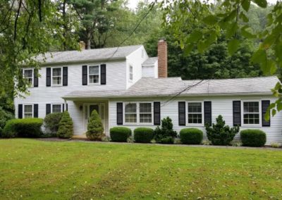 A white house with black shutters and windows.