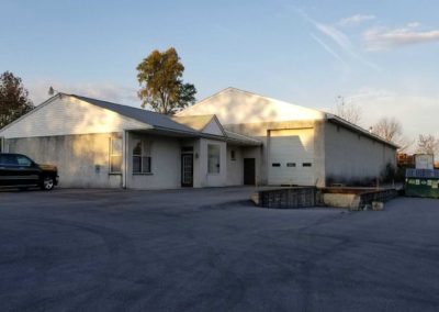 A large white building with a garage door.